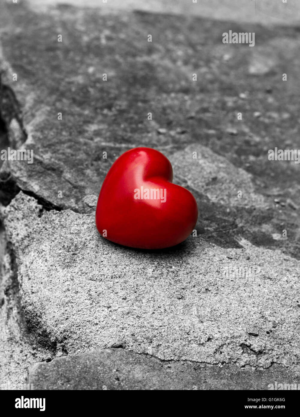 einsame rotes Herz auf einer Straße, Symbol der Einsamkeit, verlorene Liebe Stockfoto