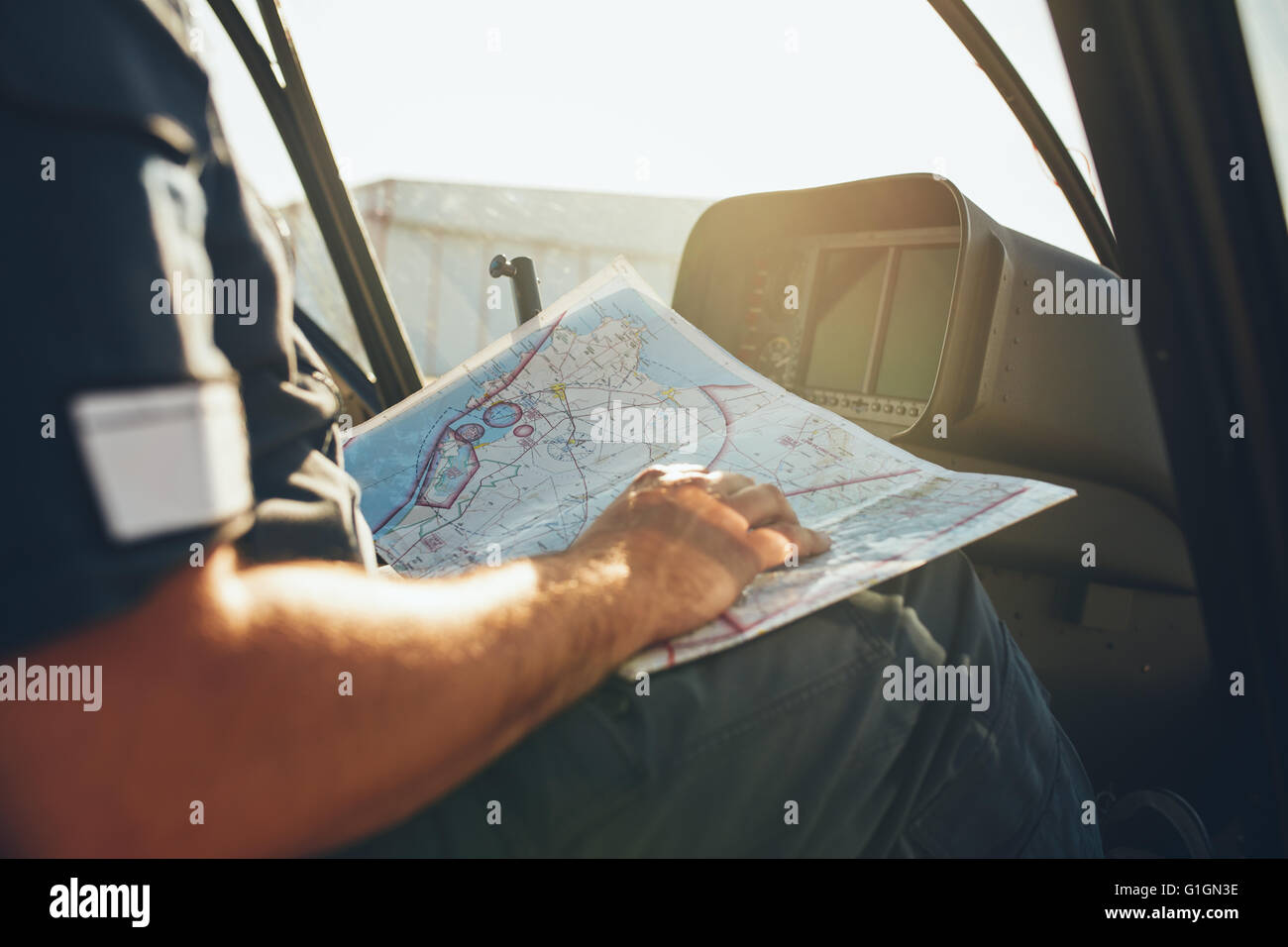 Aufnahme eines Hubschrauberpiloten studieren die Flug-Route-Map beim Sitzen im Cockpit des Flugzeugs hautnah. Pilot Lesung fl Stockfoto