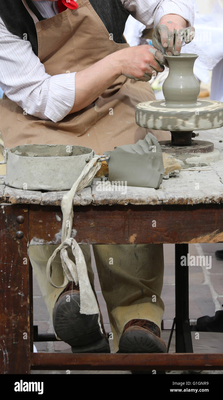 Handwerker-Potter mit der Hand Drehmaschine während der Produktion eines Topfes Stockfoto