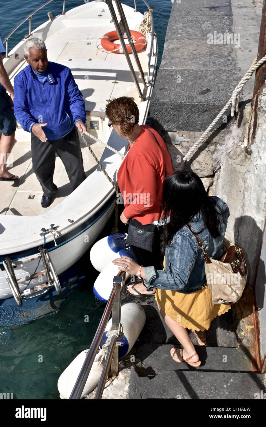 Eine Frau, die ein Boot auf der Küste von Capri Insel Stockfoto