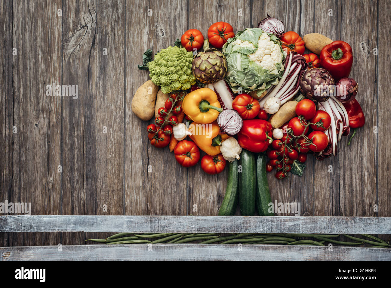 Bunte üppige Baum aus erntefrischen Bio-Gemüse auf einem rustikalen hölzernen Tisch, Ernährung und Natur-Konzept Stockfoto