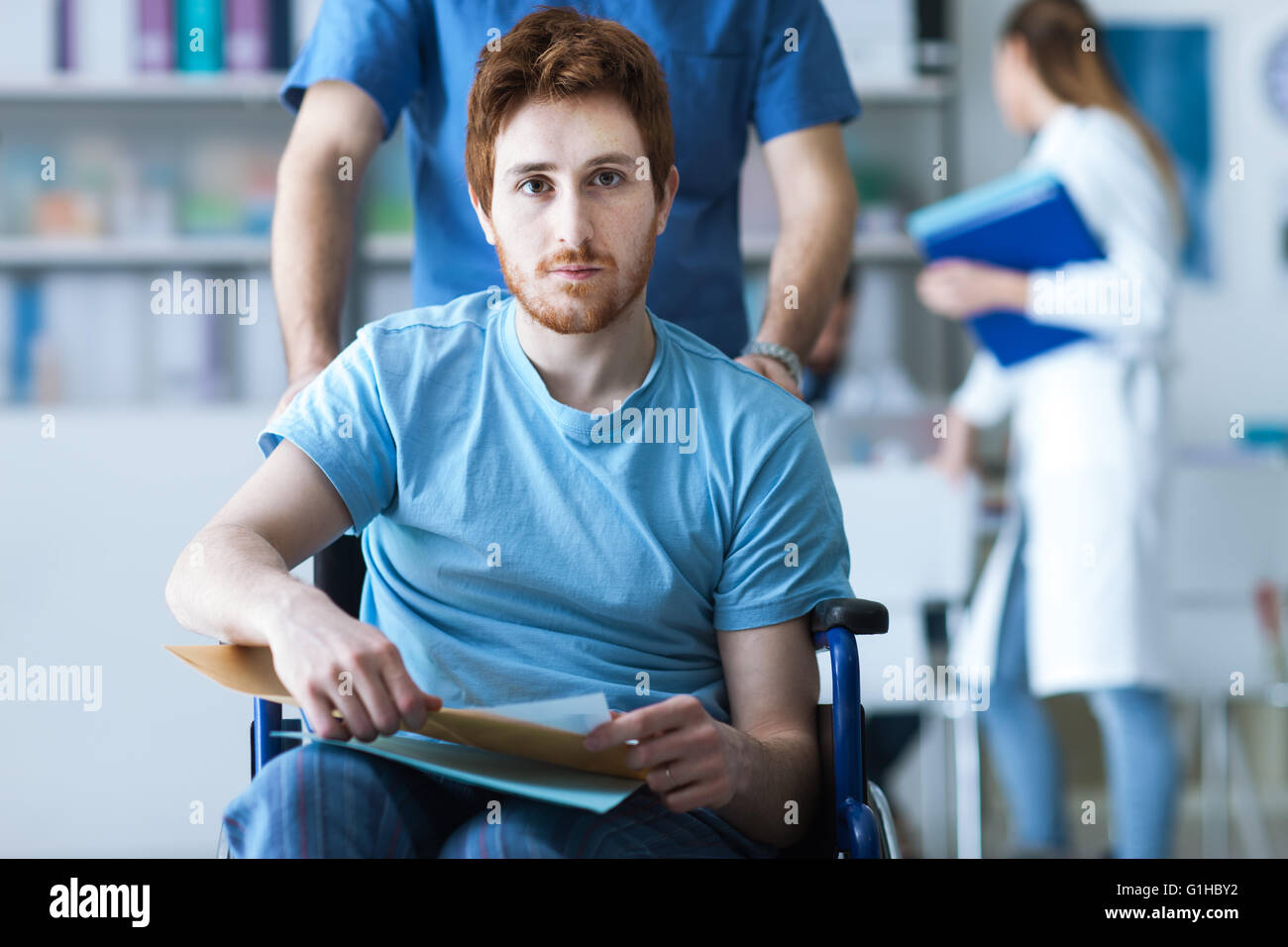 Behinderte junge Mann im Rollstuhl überprüft seine Krankenakte, treibt ein Pfleger ihn, Krankheit und medizinisches Konzept Stockfoto