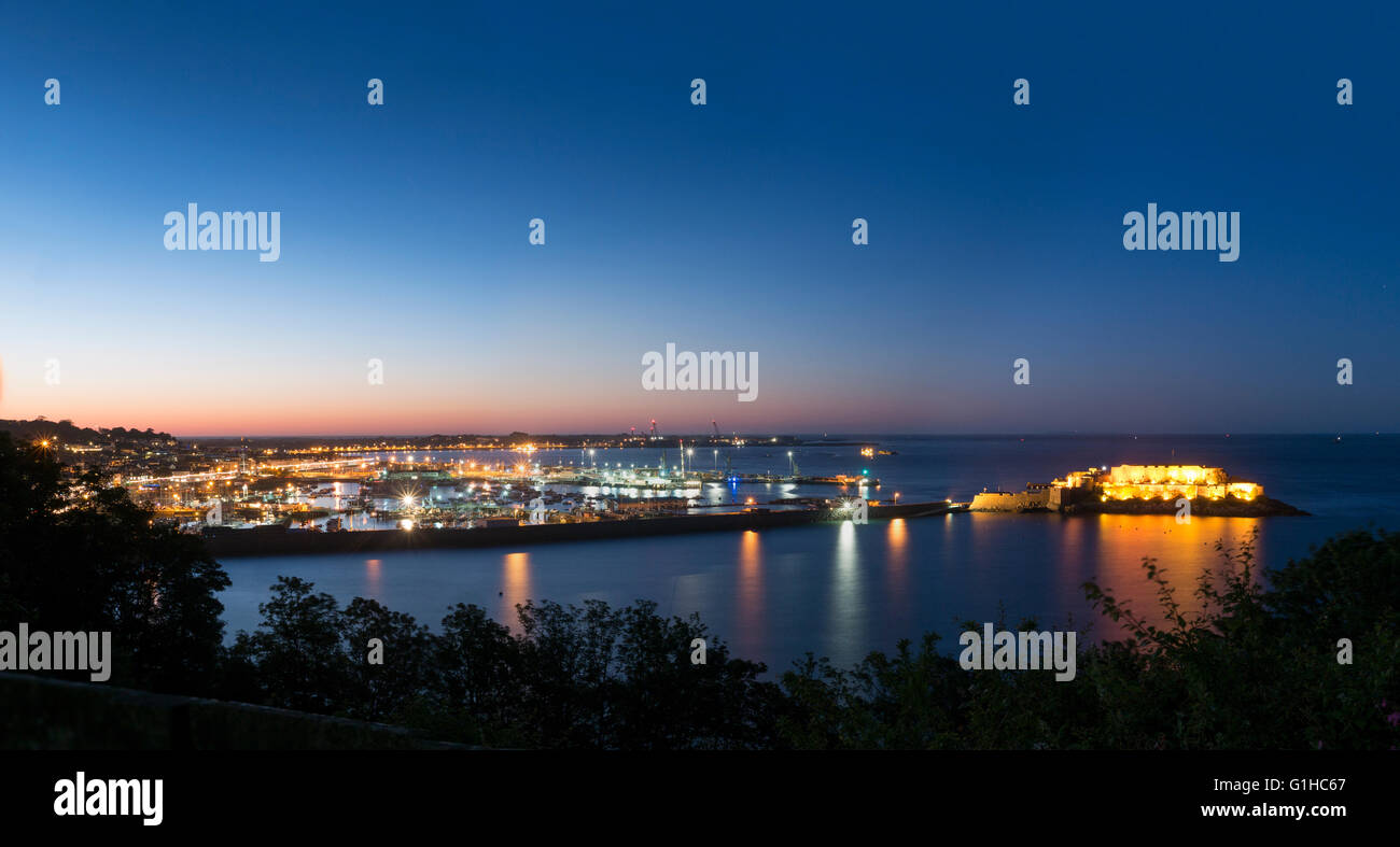 Einen Panoramablick auf den Hafen und die Stadt St. Peter Port, die Hauptstadt von Guernsey, Channel Islands in der Nacht an einem ruhigen Tag. Stockfoto