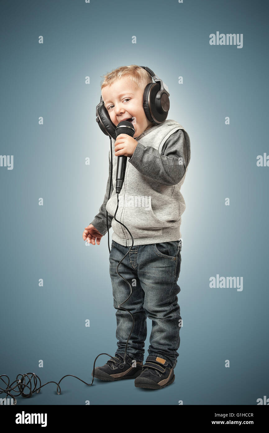 kleines Kind mit Mikrofon und Kopfhörer Stockfoto