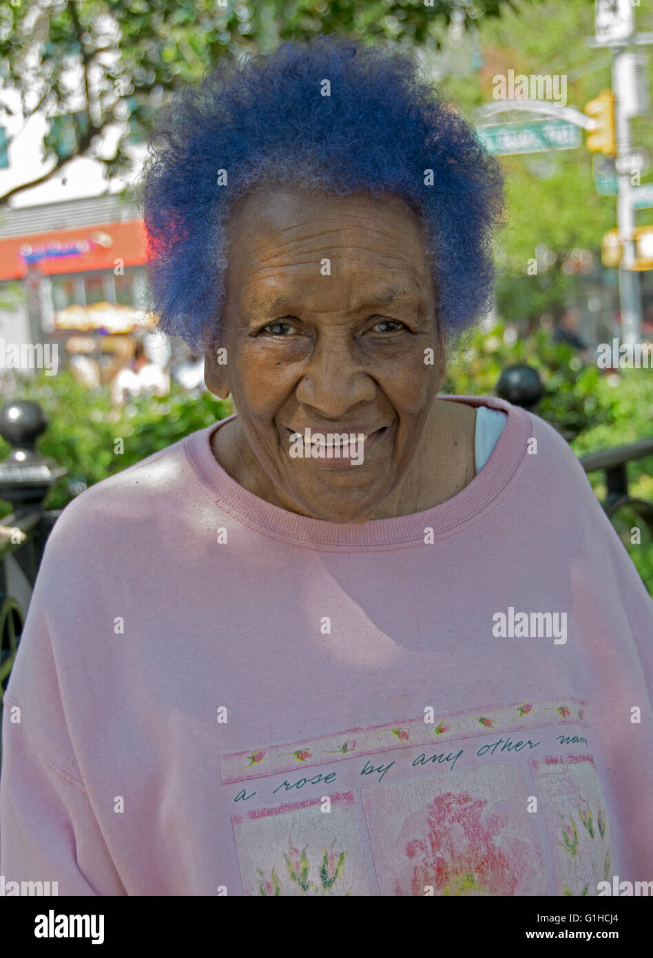 Porträt einer afrikanischen Frau in ihrer Mitte der 60er Jahre mit blauen Haaren. Im Union Square Park in Manhattan, New York City. Stockfoto