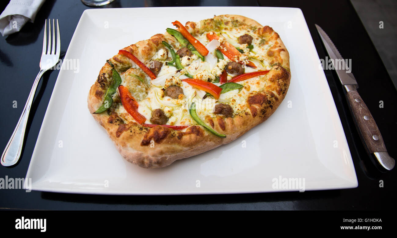 Nahaufnahme, eine frische Pizza in einem Restaurant mit Fleischbällchen, rote und grüne Paprika und Mozzarella-Käse. Stockfoto