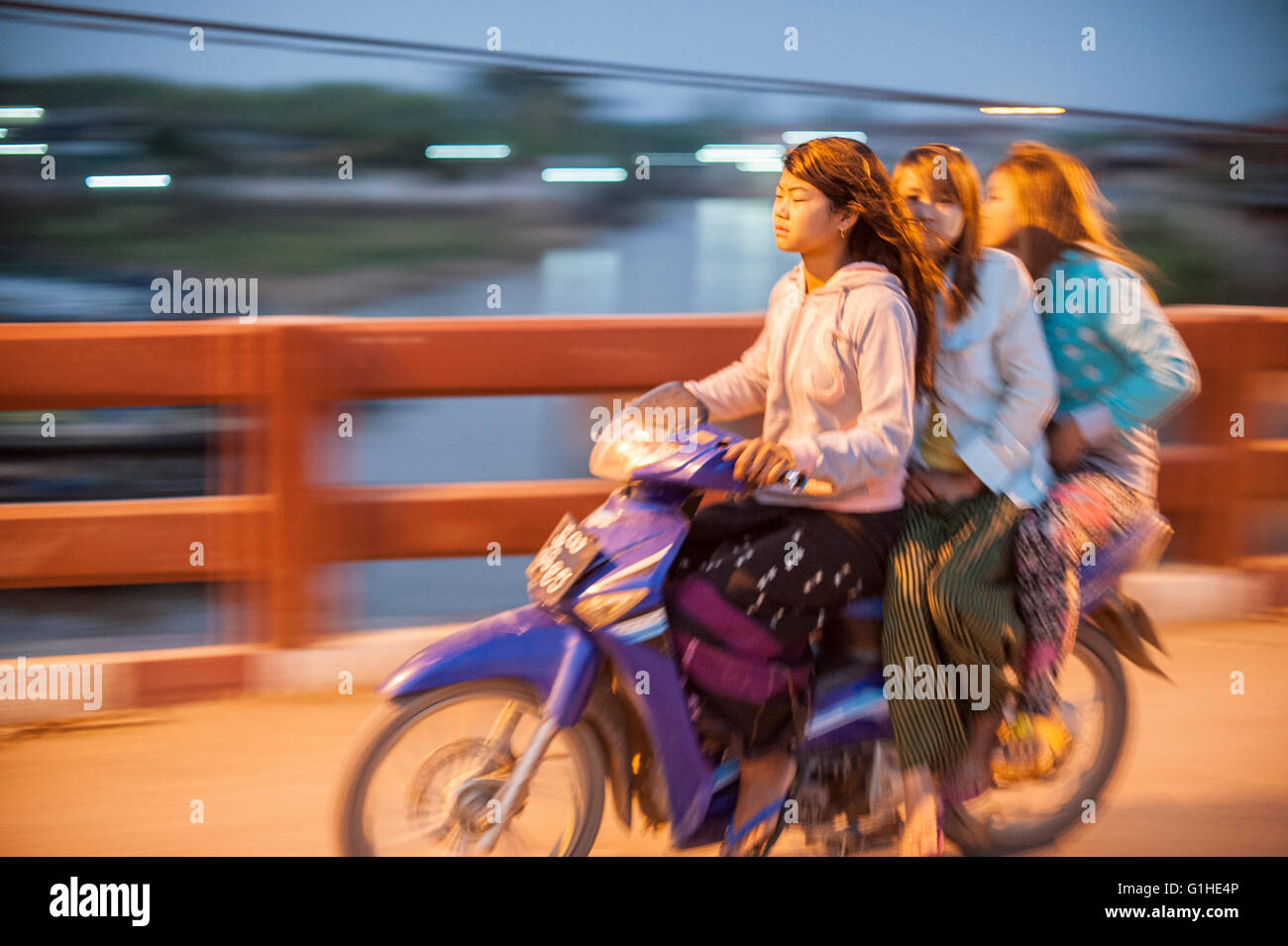 Drei Myanmar birmanischen Frauen auf einem Motorrad auf einer Brücke am Inle See, Myanmar, Burma. Stockfoto