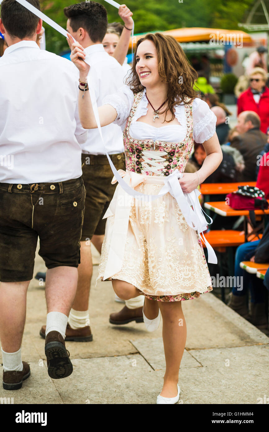 Porträt der jungen Frau in einem Kleid, einer traditionellen Folk Tanz um einen Maibaum hält ein weißes Band, Bayern, Deutschland Stockfoto