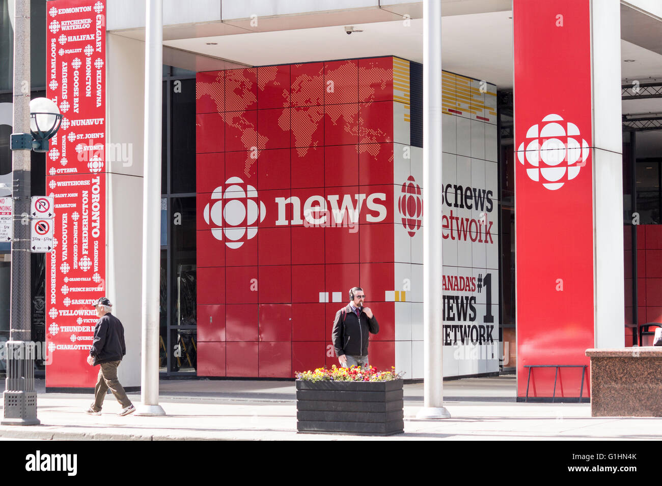 Menschen zu Fuß hinter dem Eingang zu den CBC News Gebäude in der Innenstadt von Toronto, Ontario, Kanada Stockfoto