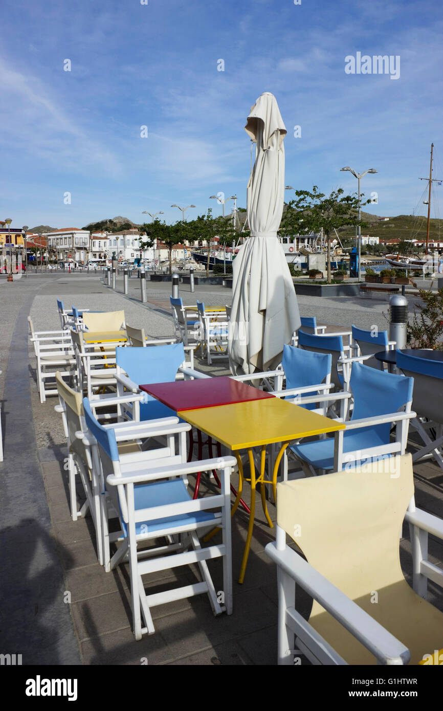 Leere Tabellen mehrfarbige & Sitze von Straßencafé "Peri Anemon' Myrina Port. Insel Limnos, Griechenland Stockfoto