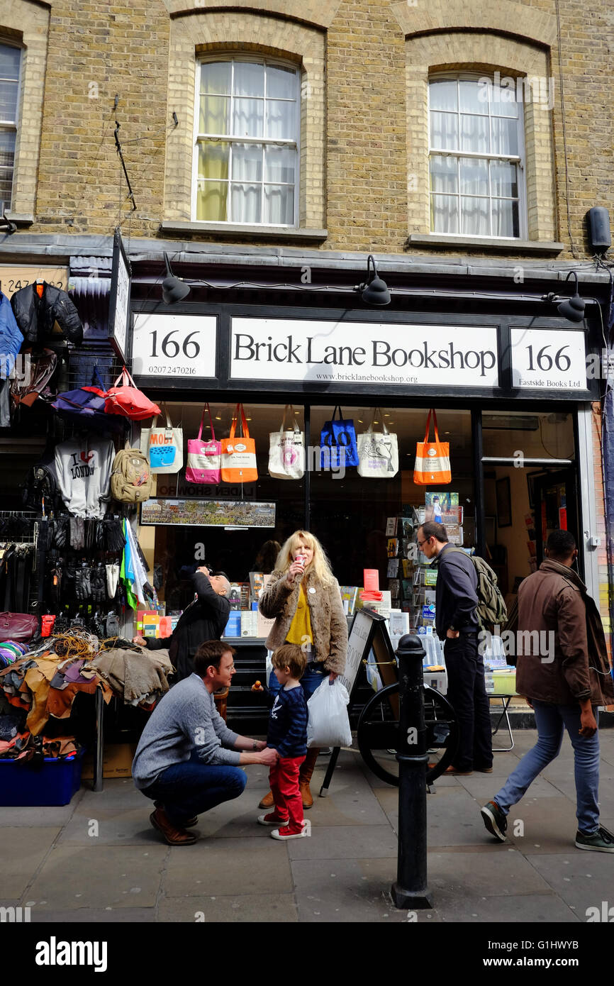 Vater spricht Kind, während Mutter trinken von Brick Lane Buchhandlung in East London hat Stockfoto