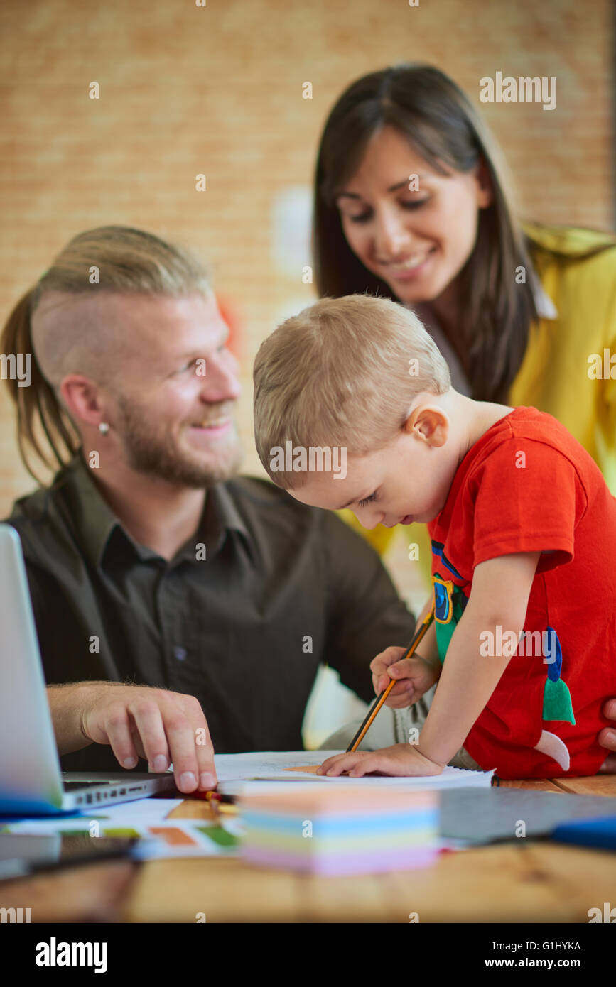 Familienbetrieb Start-up-Konzept, Mann arbeitet im Home Office, Mutter mit Sohn ihm zu helfen. Stockfoto