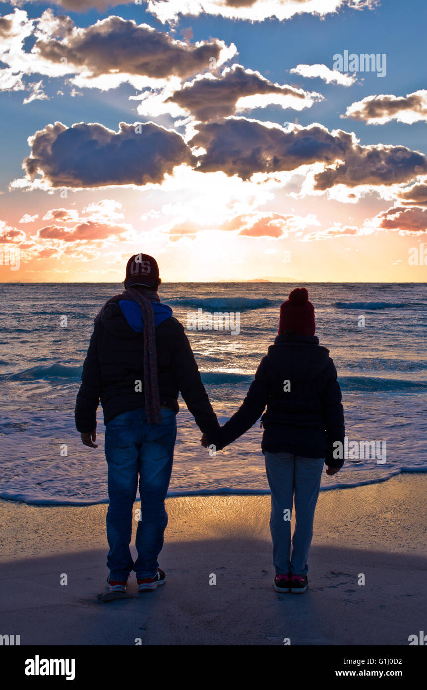 zwei Menschen, die den Sonnenuntergang, die im Meer schlafen geht Stockfoto