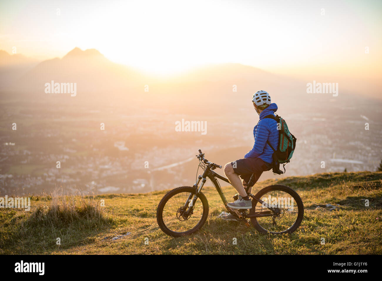 Mann auf Mountainbike Blick auf Blick auf den Sonnenuntergang, Salzburg, Österreich Stockfoto