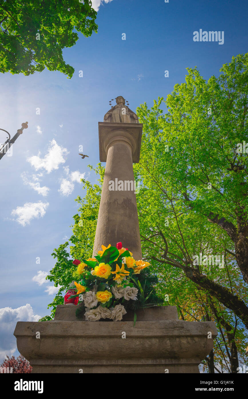 Madonnenschrein, niedriger Winkel Blick auf eine straßenseitige Gedenkstätte in Form einer Madonna auf einer Säule neben Rekawka im Krakauer Stadtteil Podgorze in Polen. Stockfoto
