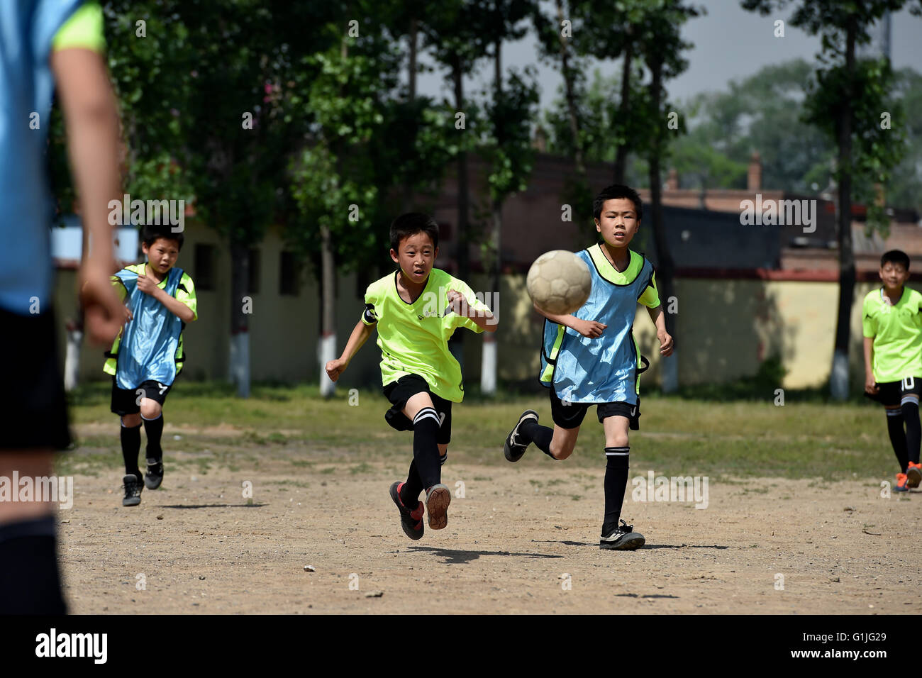 (160517)--SHANXI, 17. Mai 2016 (Xinhua)--Studenten der Sima-Grundschule für ein Fußballspiel in Xiaoyi Stadt, Nord-China Shanxi Provinz, 17. Mai 2016 laufen. Viele Dorfschulen haben weitere Sportkurse während dieser Jahre einrichten wie sie ermutigt werden, mehr Sportunterricht hinzufügen, wenn die Bedingungen dies zulassen. Eine 2014-Studie ergab, dass 23 Prozent der chinesischen Jungen unter 20 Jahren übergewichtig waren oder fettleibig, während die Zahl lag bei 14 Prozent für Mädchen.  (Xinhua/Zhan Yan) (Wyl) Stockfoto