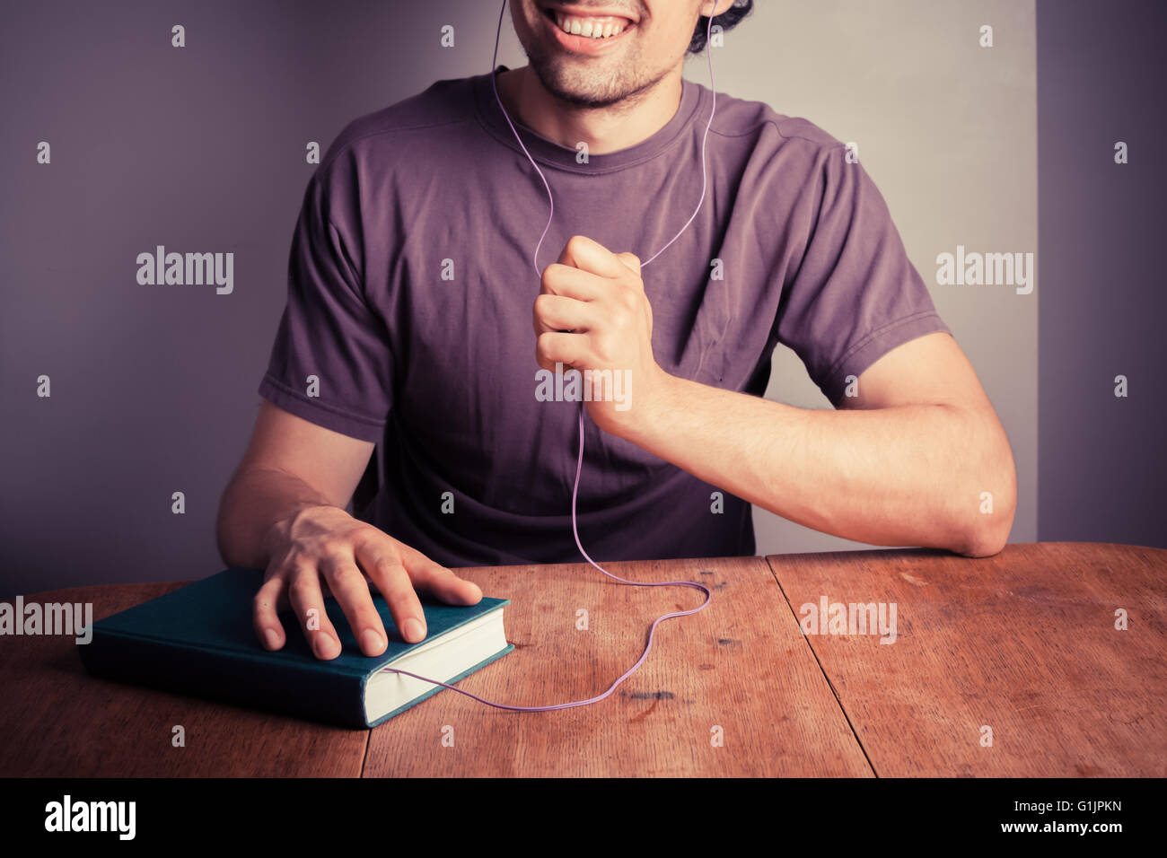 Ein glücklicher junge Mann ist ein Audiobuch hören Stockfoto