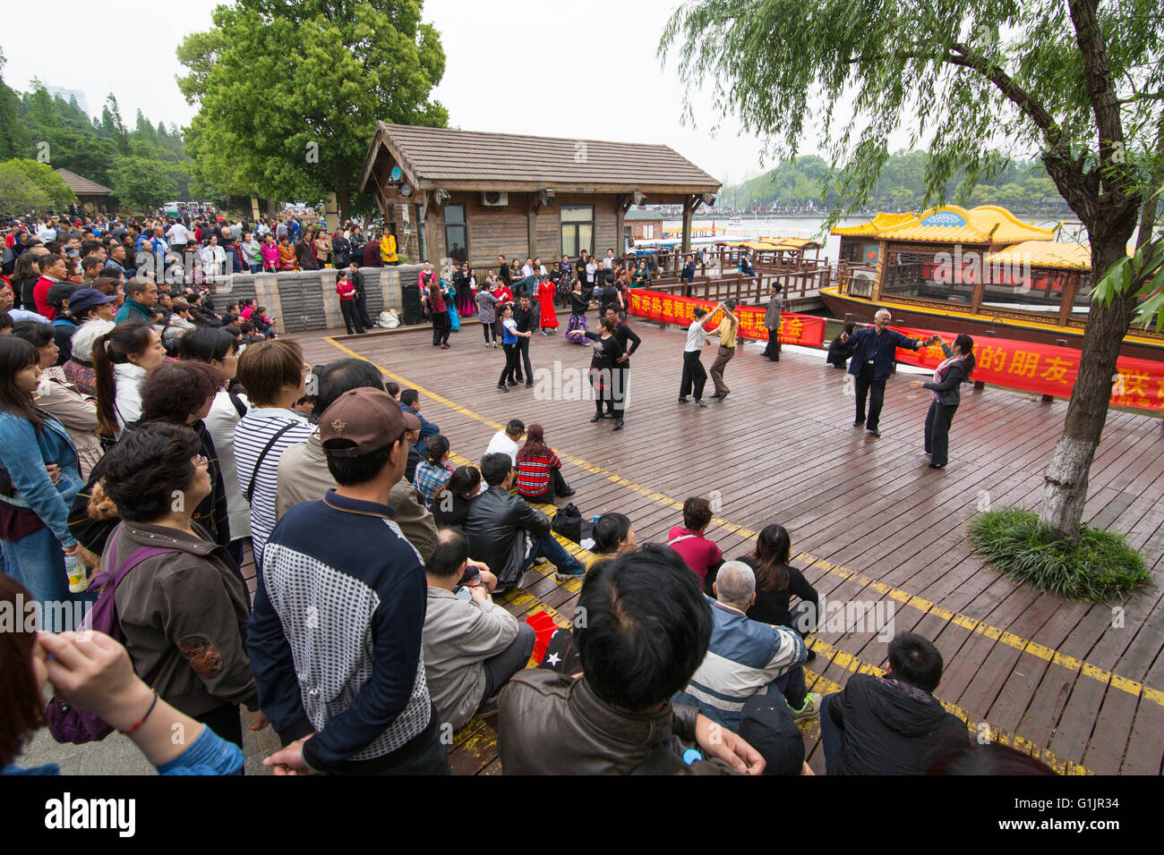 Sportlich Chinesen aktive Gesellschaftstanz in an einem Sonntag im geschäftigen Xuanwuhu Park, mit Zuschauern Nanjing, China Stockfoto