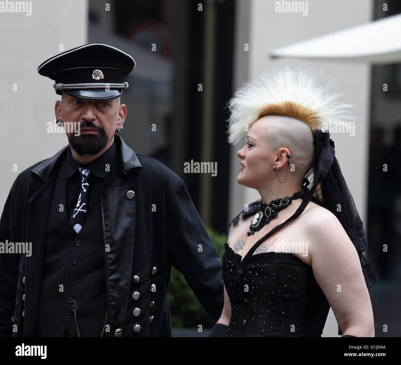 Gothic Festival (Gotik-Wave-Treffen) Leipzig, Deutschland, 13. bis 5. Mai 2016. Mann in schwarz mit militärischen Hut & Mädchen mit Irokesenschnitt Haar Stockfoto