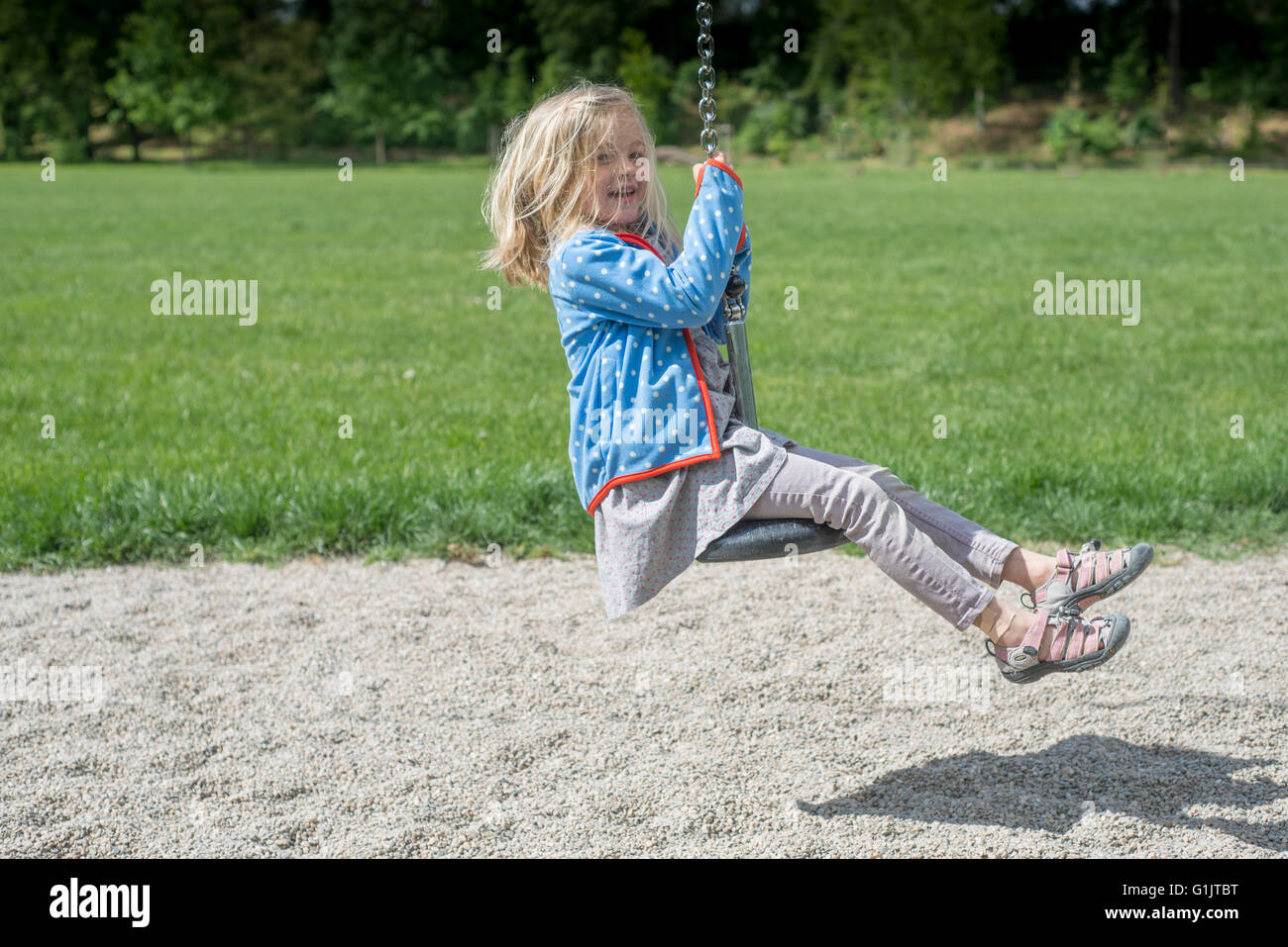 Glückliches Kind blondes Mädchen (5 Jahre) befreit auf Flying Fox Spielgeräten auf einem Kinderspielplatz. Im Sommer Stockfoto