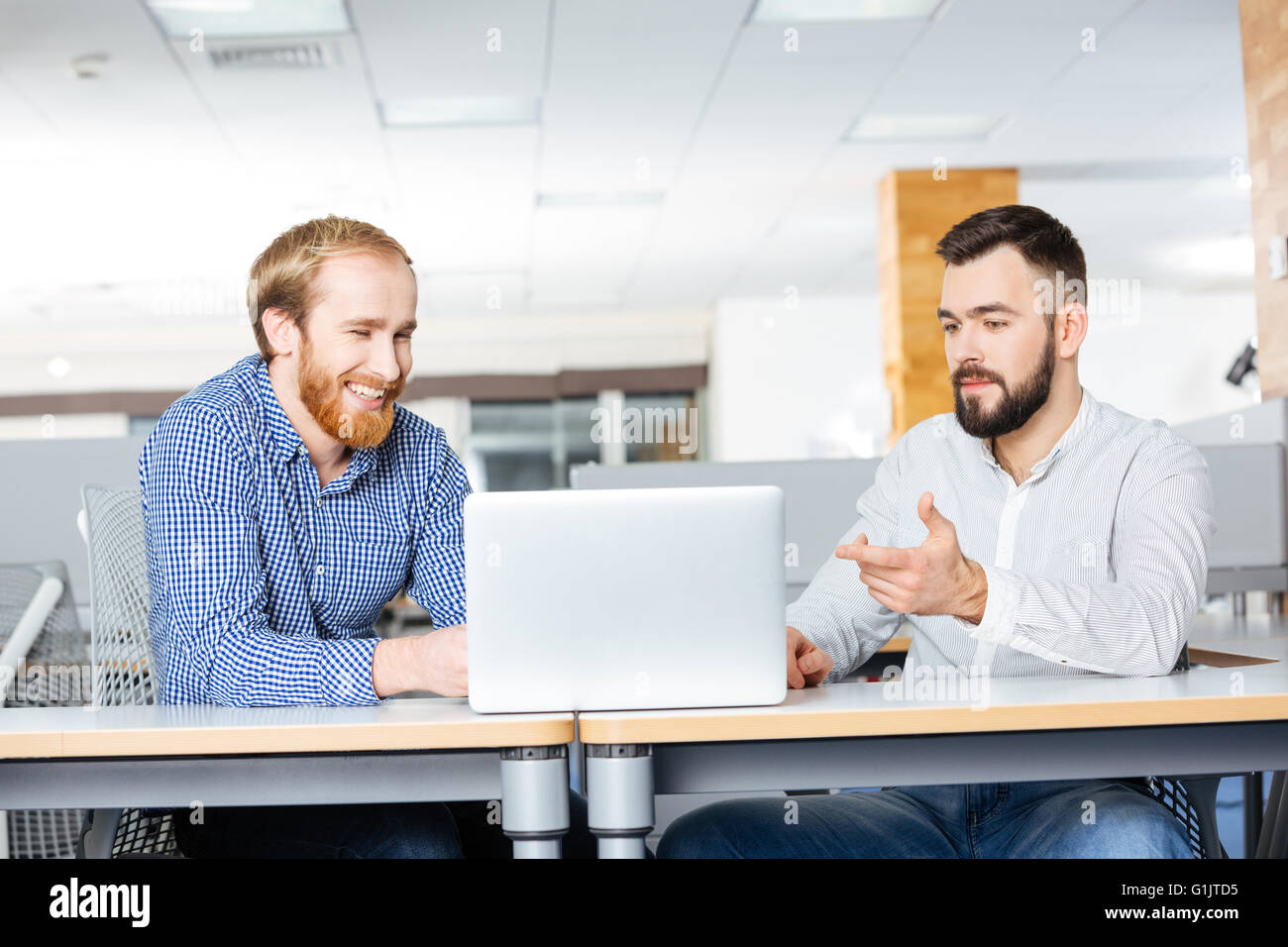 Zwei glückliche bärtigen Geschäftsmann mit Laptop im Büro zusammen zu arbeiten Stockfoto