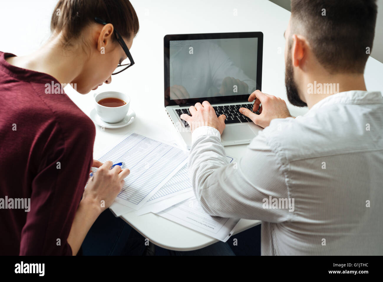 Rückansicht von zwei fokussierte ernsthafte Geschäftsleute mit Laptop zusammen im Tagungsraum Stockfoto