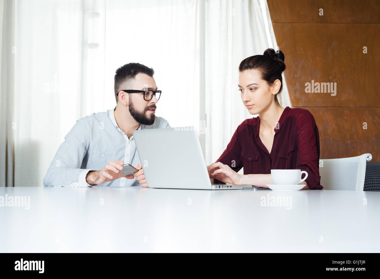 Zwei konzentriert junge Unternehmer mit Laptop im Tagungsraum zusammen arbeiten Stockfoto