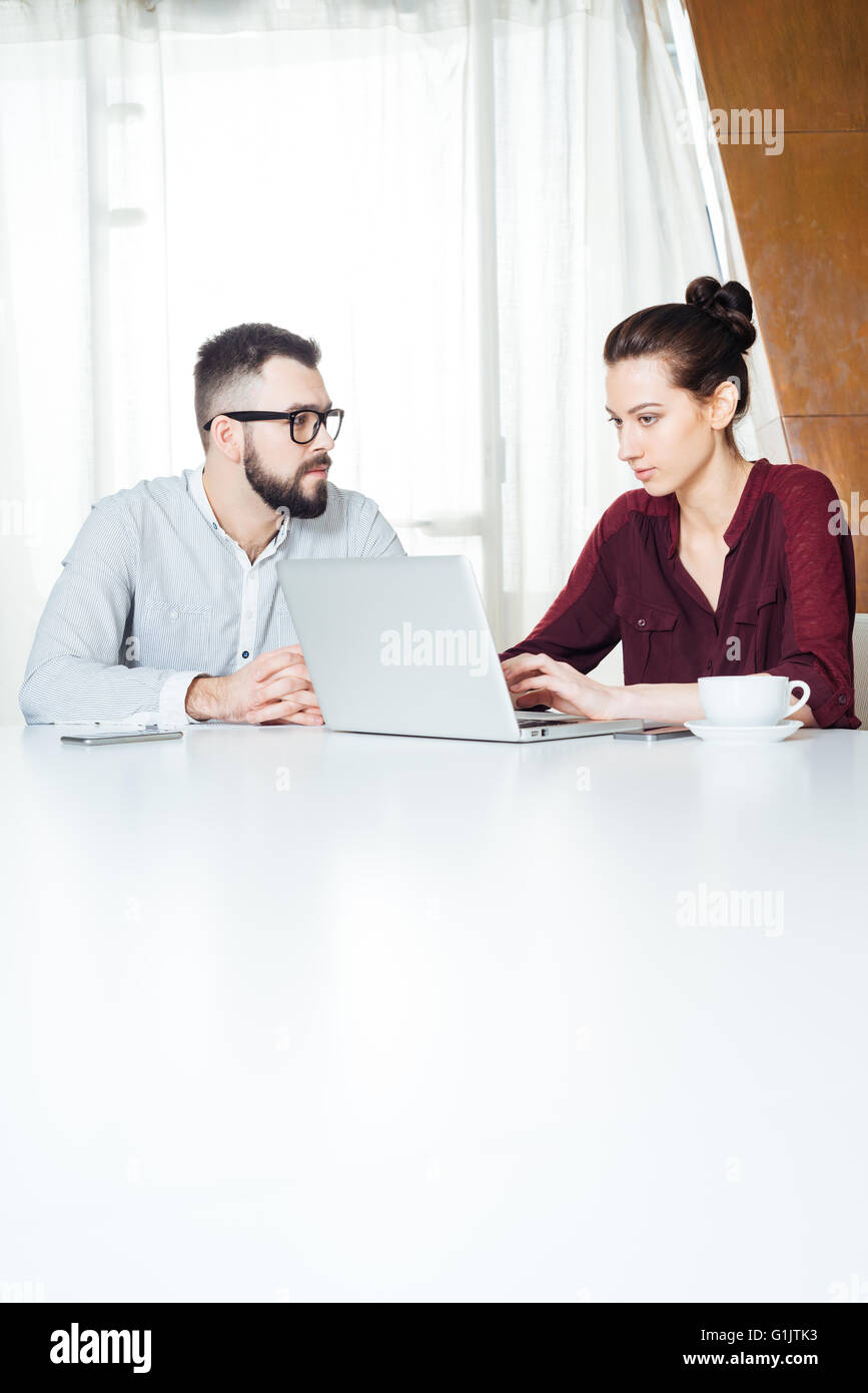 Zwei konzentriert junge Unternehmer arbeiten und mit Laptop auf der Sitzung im Büro Stockfoto