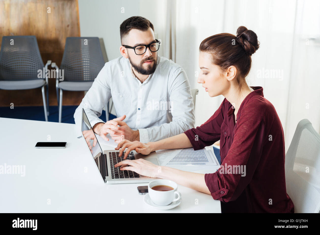 Zwei junge Unternehmer auf Laptop tippen und Zusammenarbeit im Büro Stockfoto
