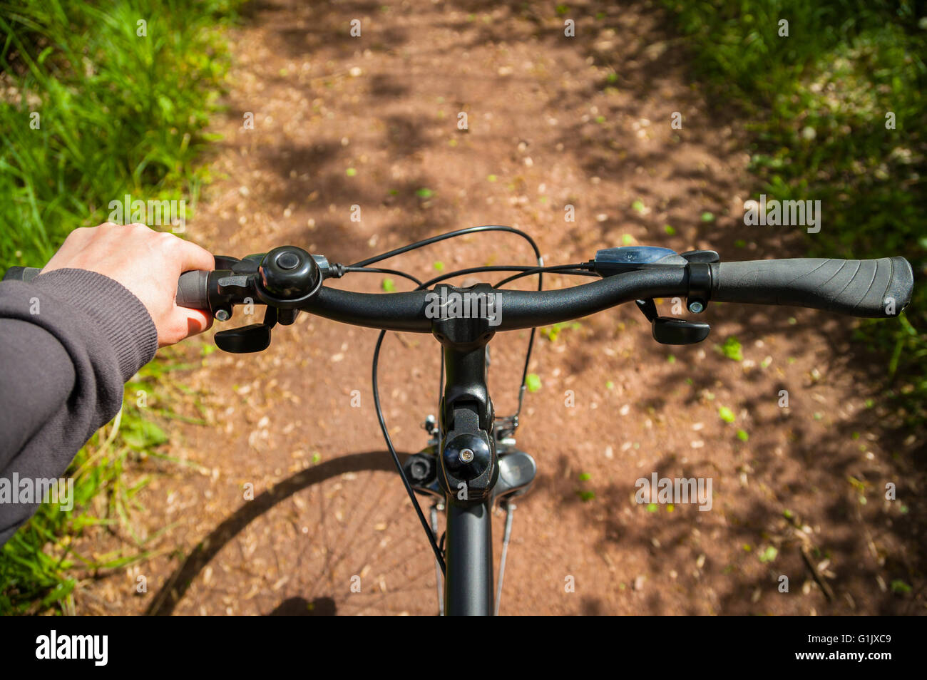 Hand aufs Fahrradlenker auf Radweg in der Natur Stockfoto