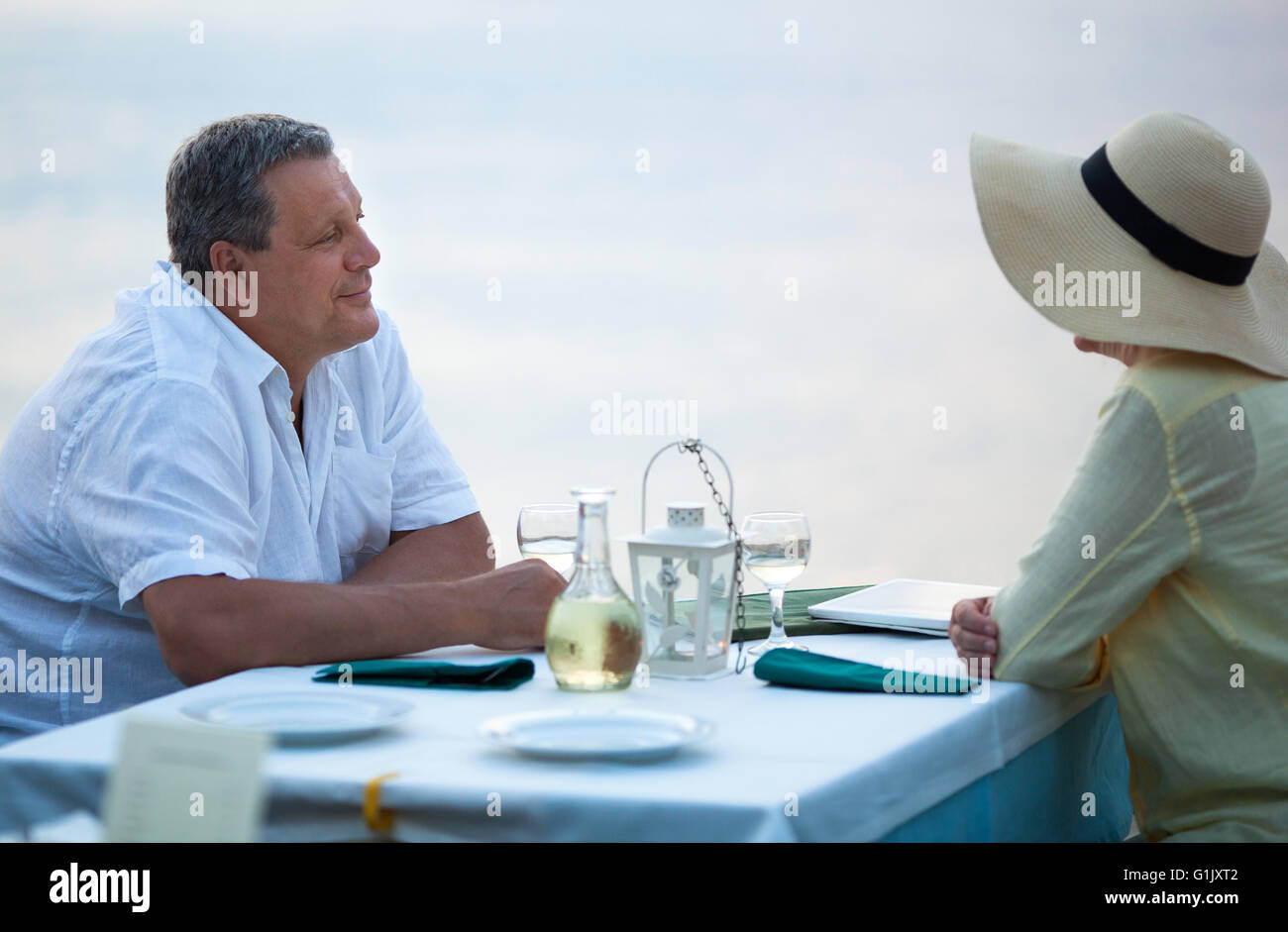 Paar mittleren Alters sitzen warten auf eine Mahlzeit Stockfoto