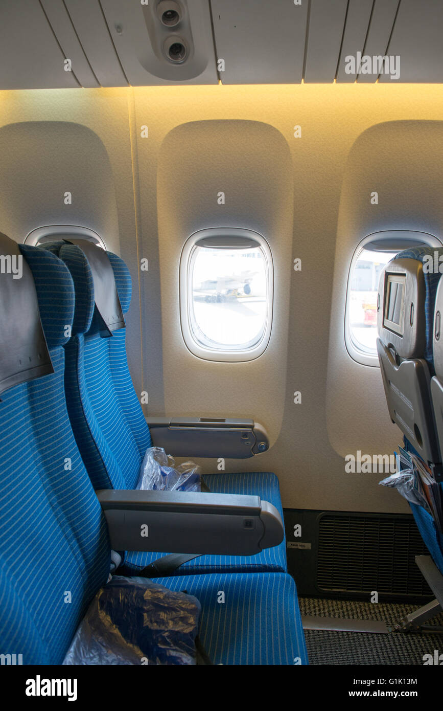 Blaue Beifahrersitz auf einem Passagierflugzeug durch Fenster Stockfoto