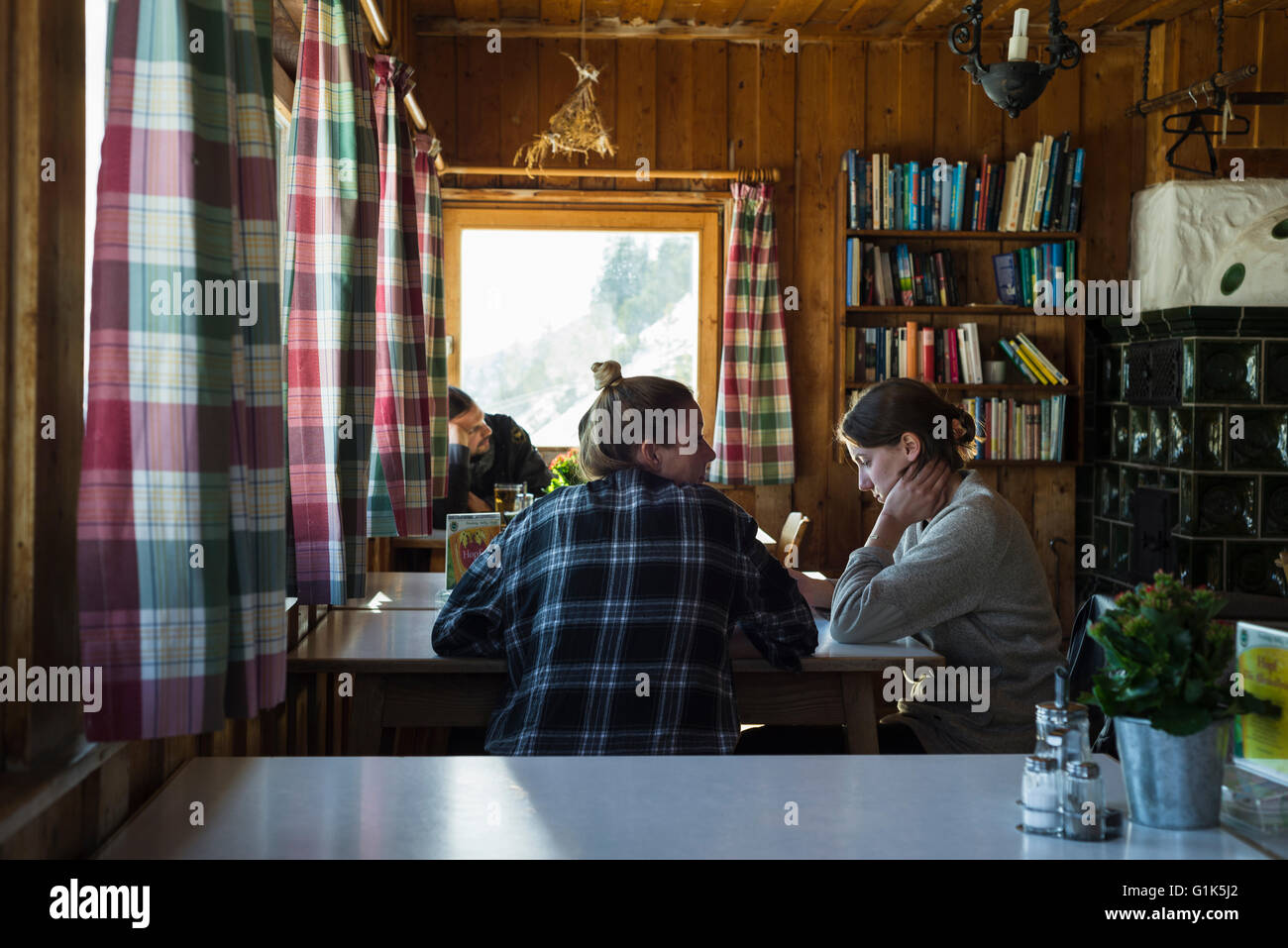 Wanderer am Tisch sitzen und entspannen in TheTölzer Hütte Speisesaal mit seinen alpinen Stil, Karwendelgebirge, Tirol, Österreich Stockfoto