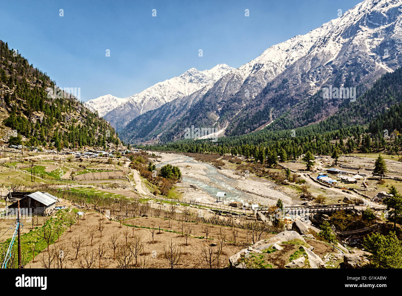Talblick im Himalaya mit Fluss und Holzbrücke. Sangla Stockfoto