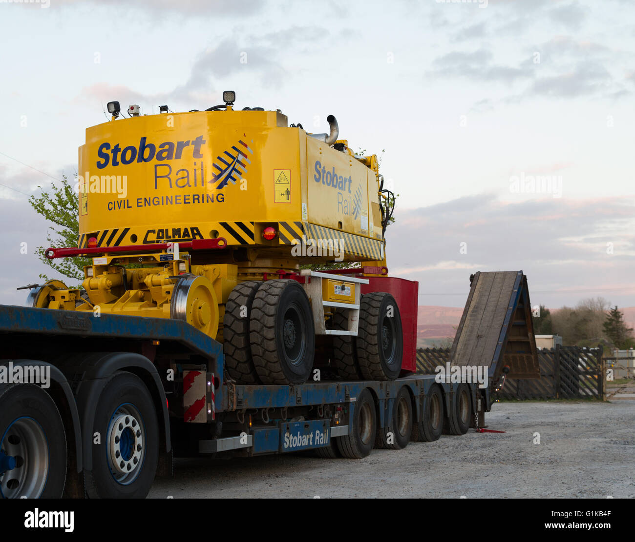 Stobart Schiene hoch-und Tiefbau Straße Schiene auf Track Pflanze Maschine steht auf einem Tieflader am Bahnhof Ribblehead Stockfoto