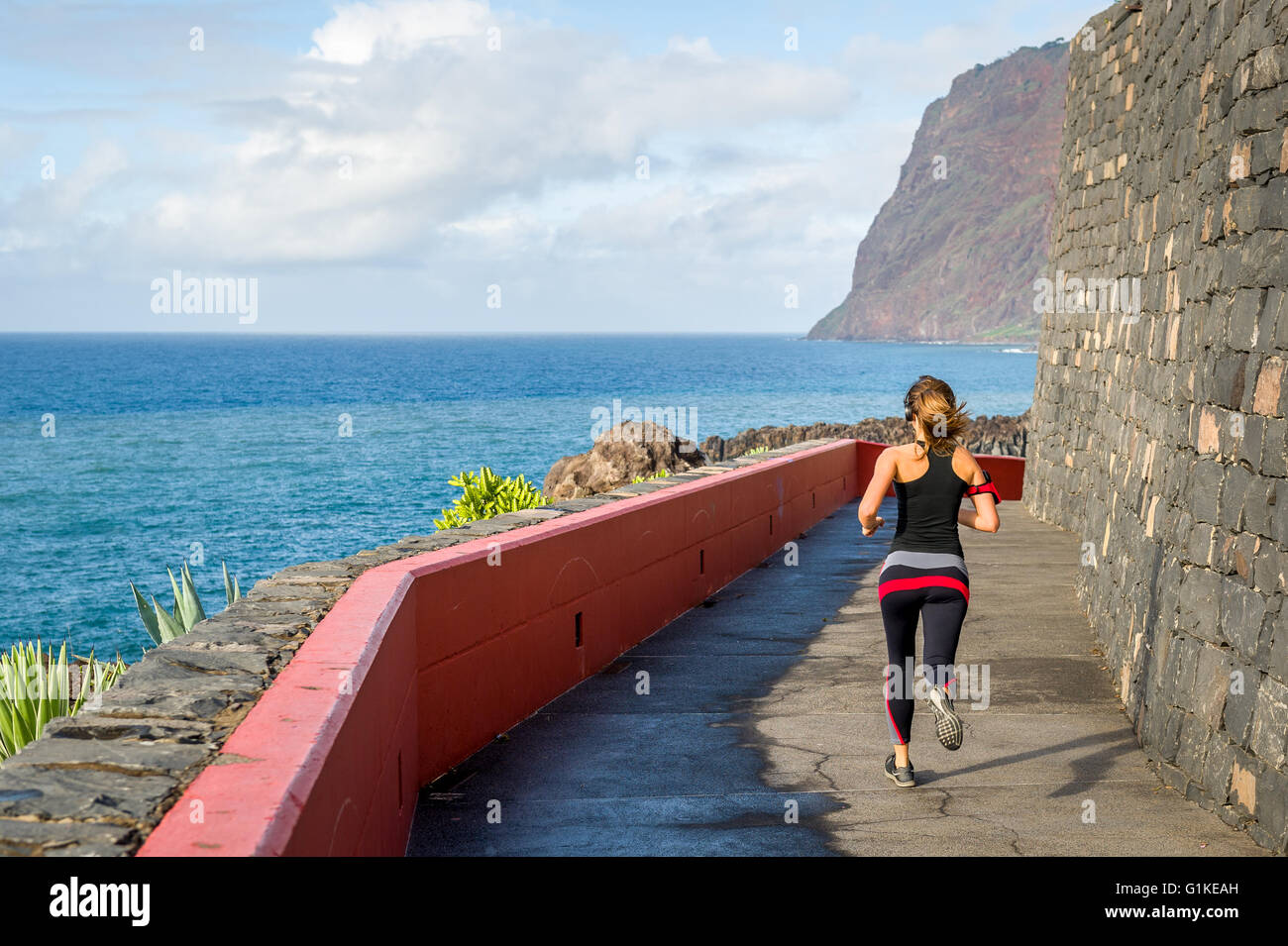 Sportliche Frau läuft am Meer Stockfoto