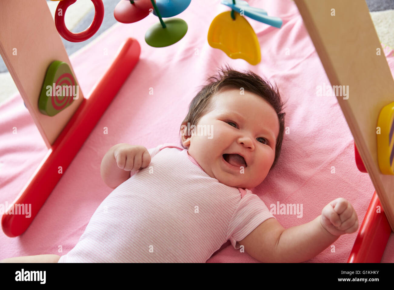 Cute Baby Girl Handauflegen rosa Decke mit mobilen Spielen Stockfoto
