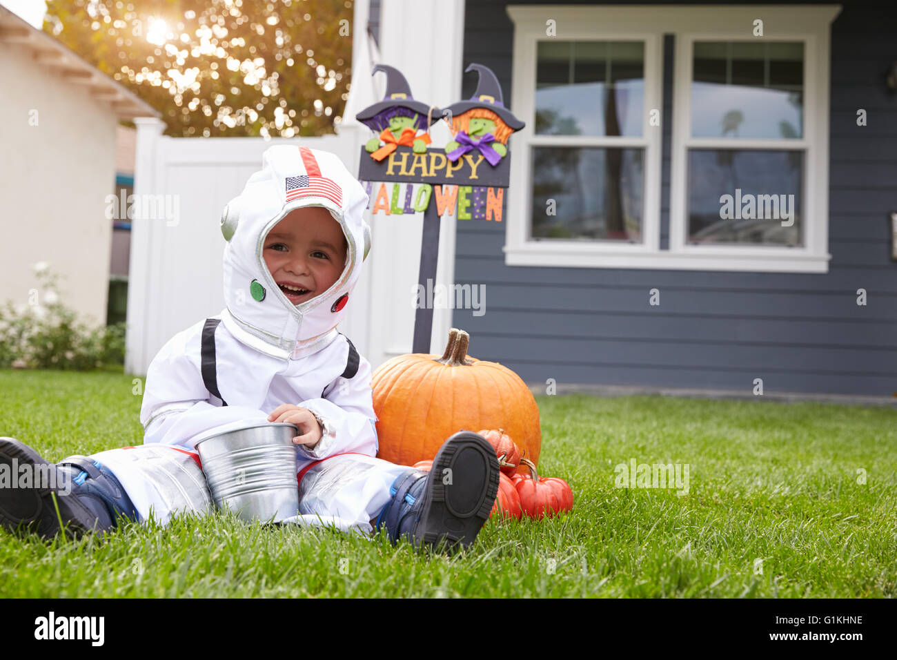 Junge gekleidet In Trick oder Behandlung von Spaceman Kostüm auf Rasen Stockfoto