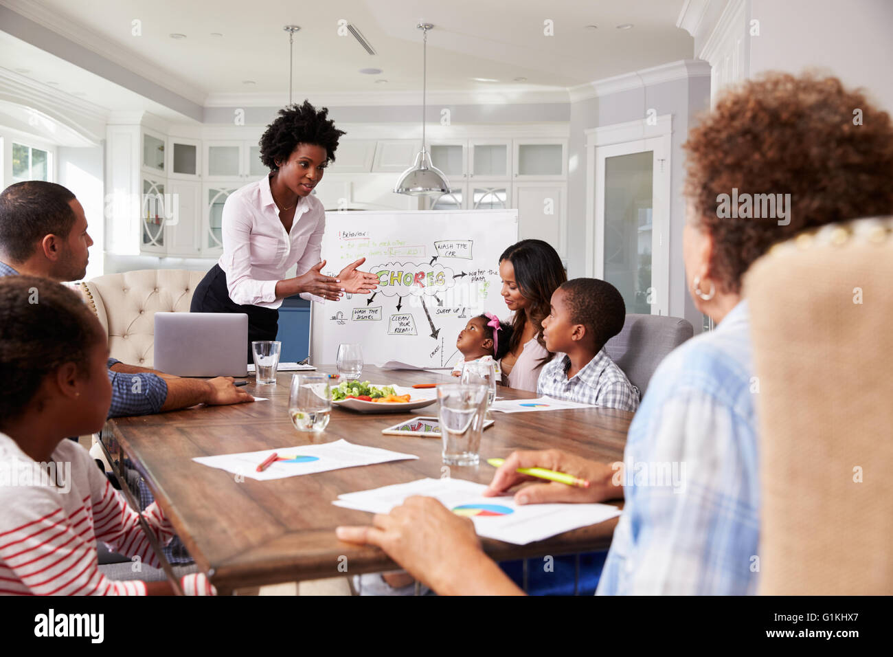 Geschäftsfrau präsentiert treffen zu einer Familie in der Küche Stockfoto