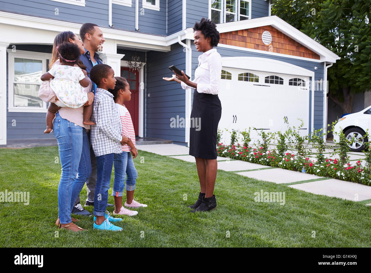 Real Estate Agent zeigt einer Familie ein Haus Stockfoto