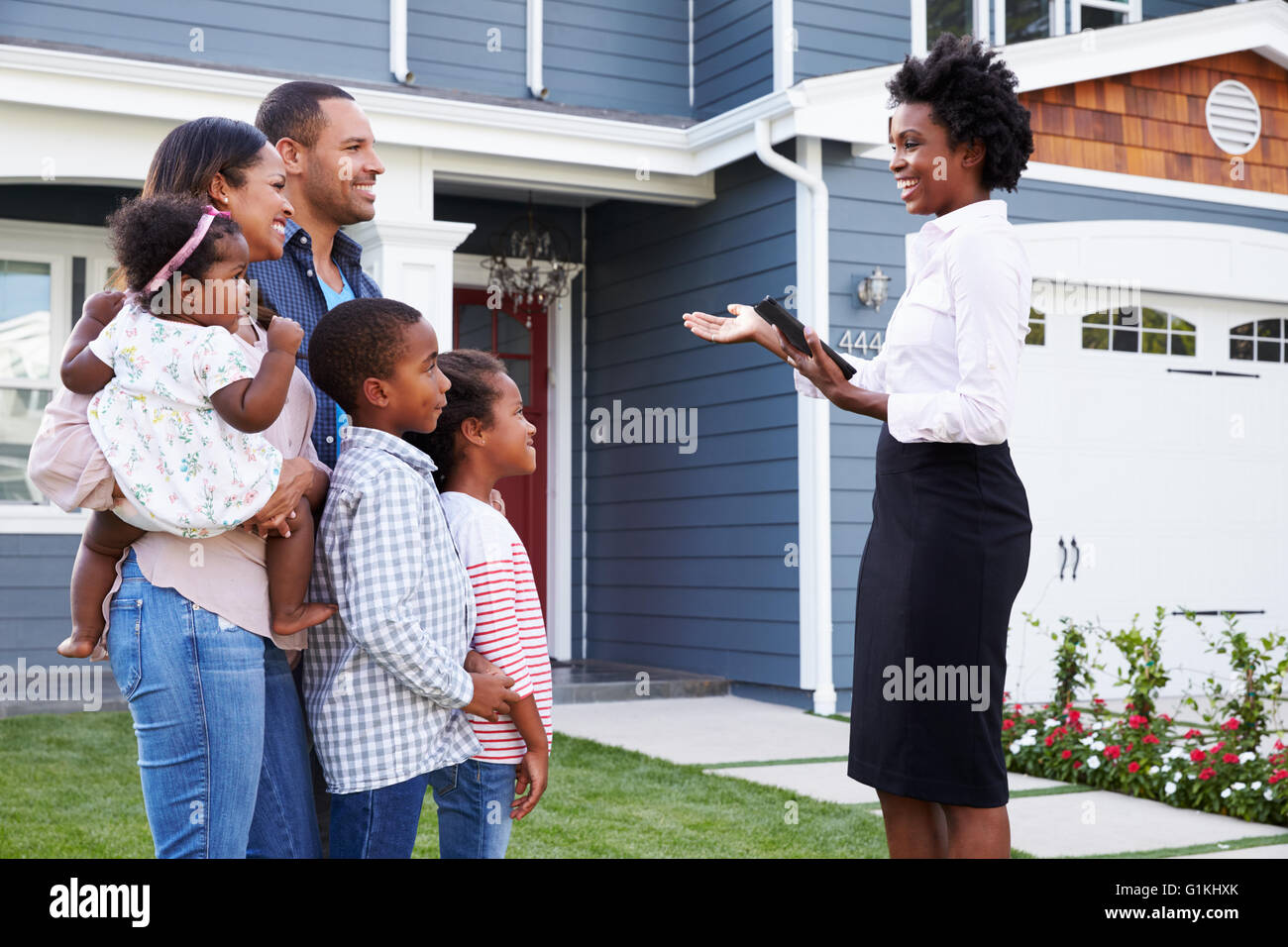 Real Estate Agent zeigt einer Familie eine Haus näher in Stockfoto
