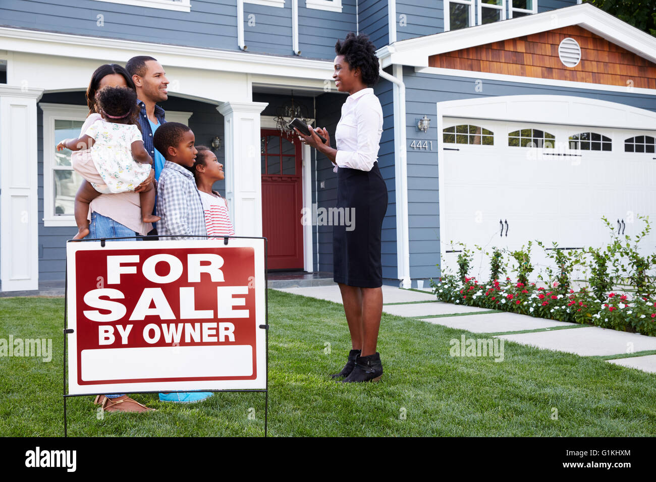 Immobilienmakler und Familie Haus mit einem Schild "zu verkaufen" Stockfoto