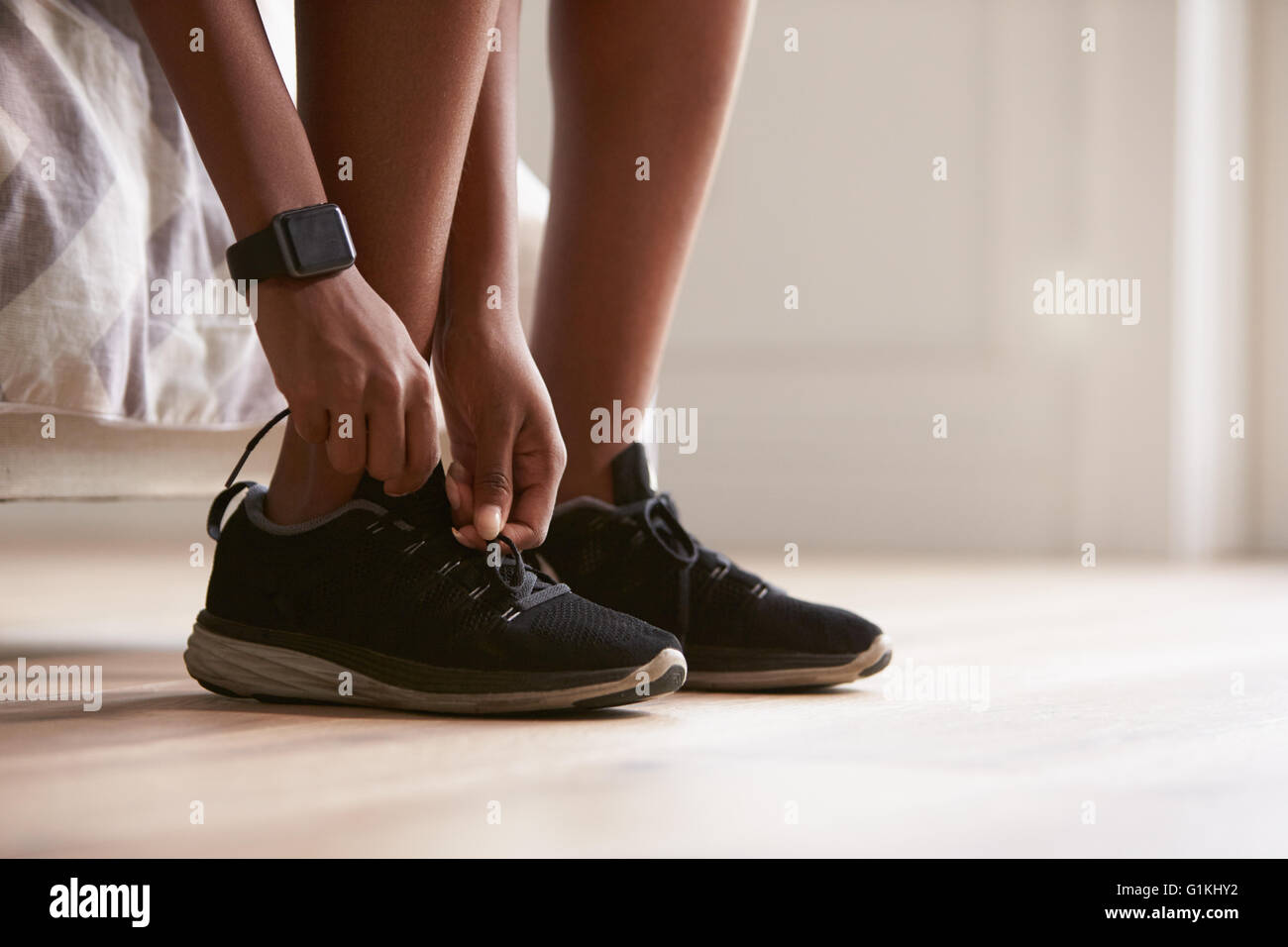 Junge schwarze Frau binden Sportschuhe, close-up Stockfoto
