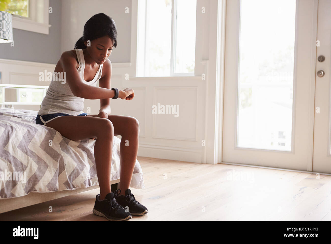 Junge schwarze Frau bereit für Übung, Überprüfung Smartwatch Stockfoto