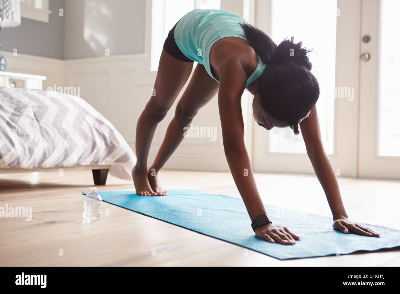 Junge schwarze Frau in den nach unten gerichteten Hund Yoga-pose Stockfoto