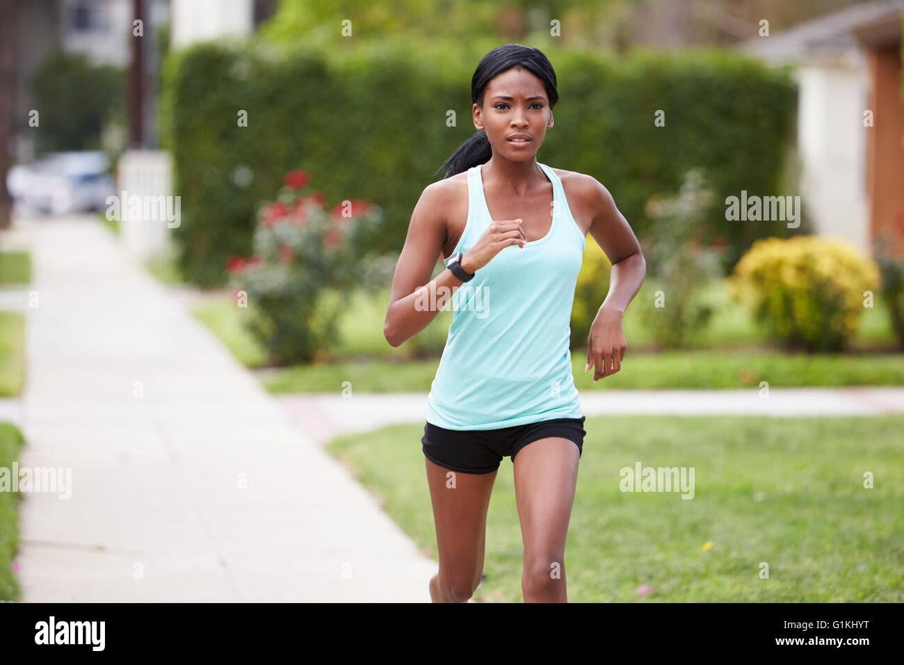 Junge schwarze Frau in Sportkleidung laufen auf der Straße Stockfoto