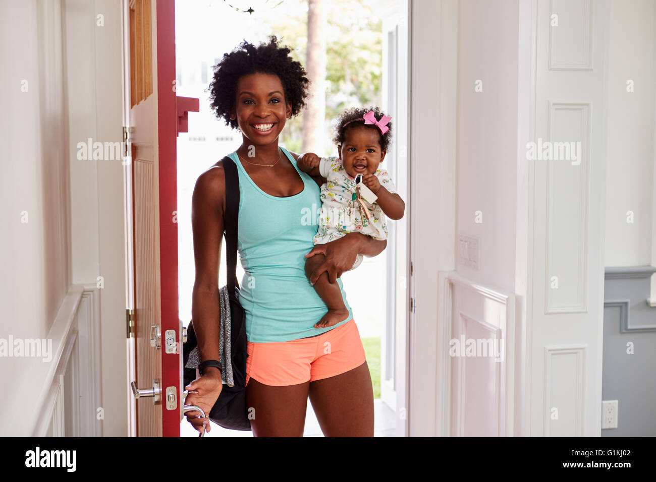 Junge schwarze Frau und Kind kommen nach Hause, nach dem Training Stockfoto