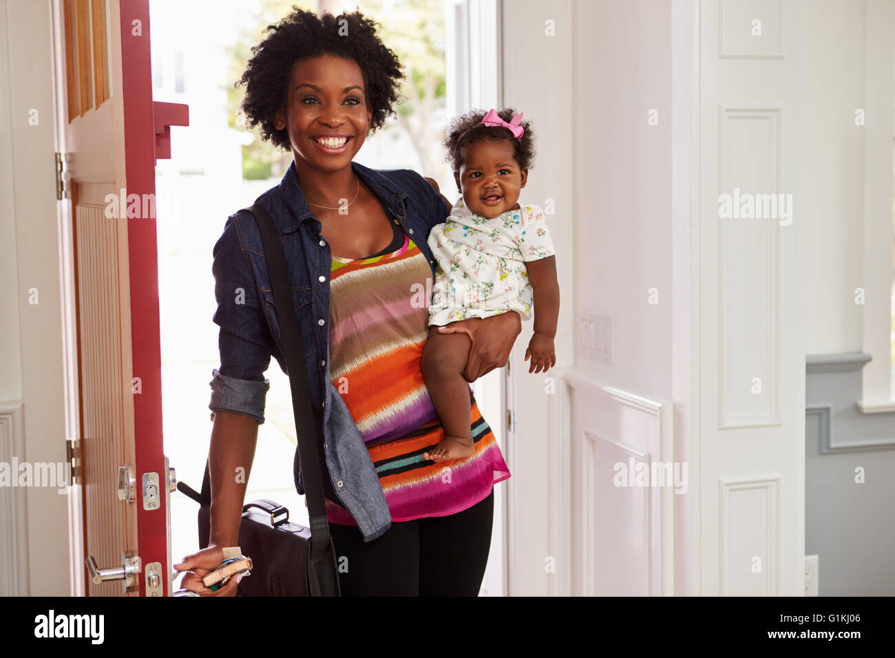Junge schwarze Frau Holding Kind zuhause angekommen Stockfoto