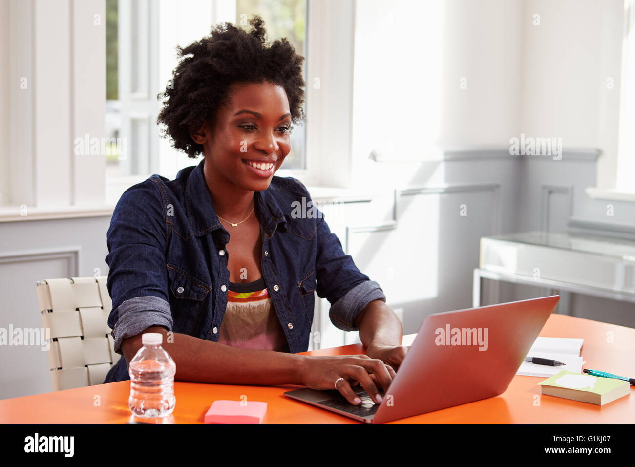 Junge schwarze Frau mit Laptop-Computer am Schreibtisch, Nahaufnahme Stockfoto