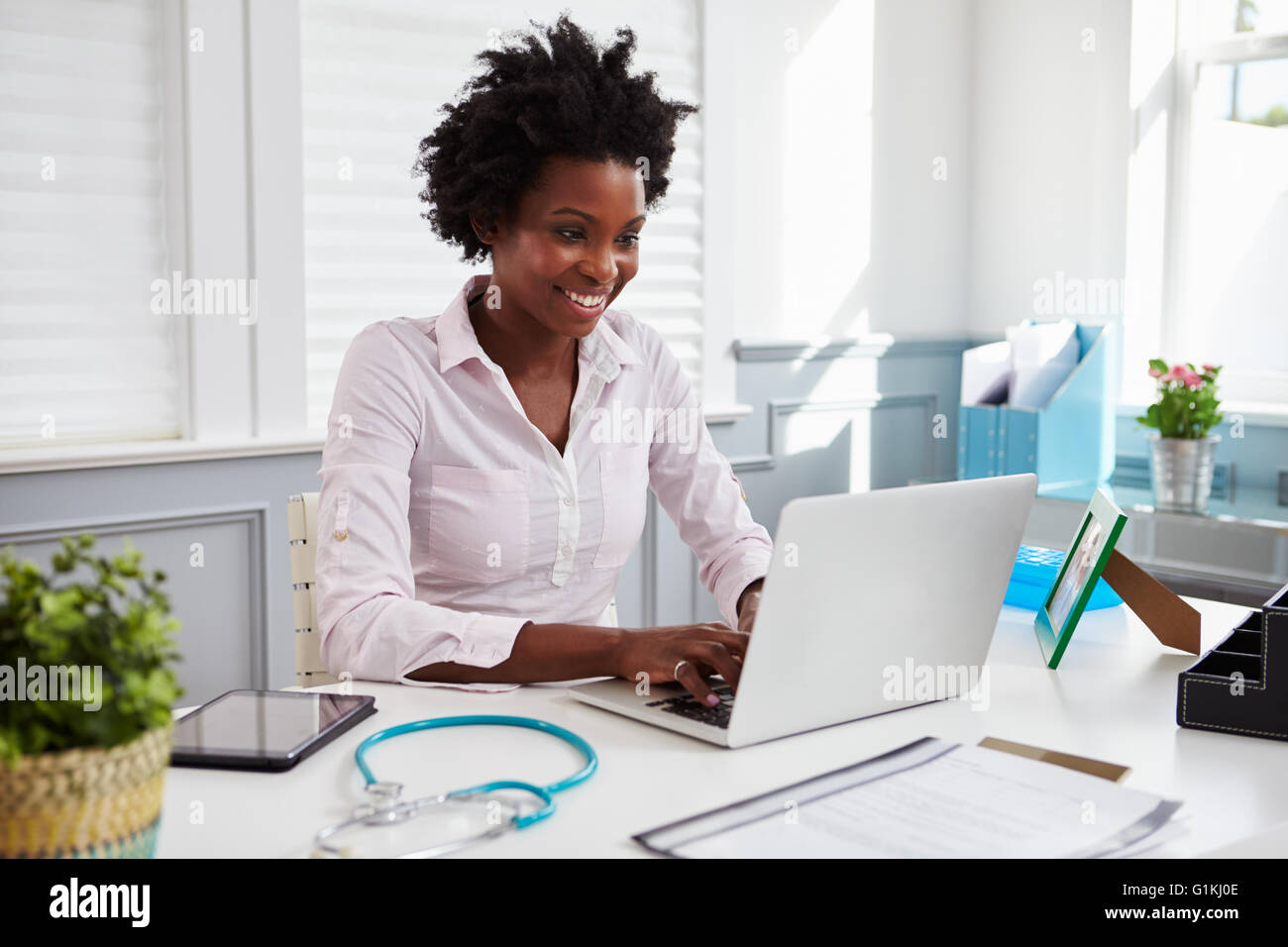 Schwarzen Ärztin bei der Arbeit im Büro mit Laptop-computer Stockfoto